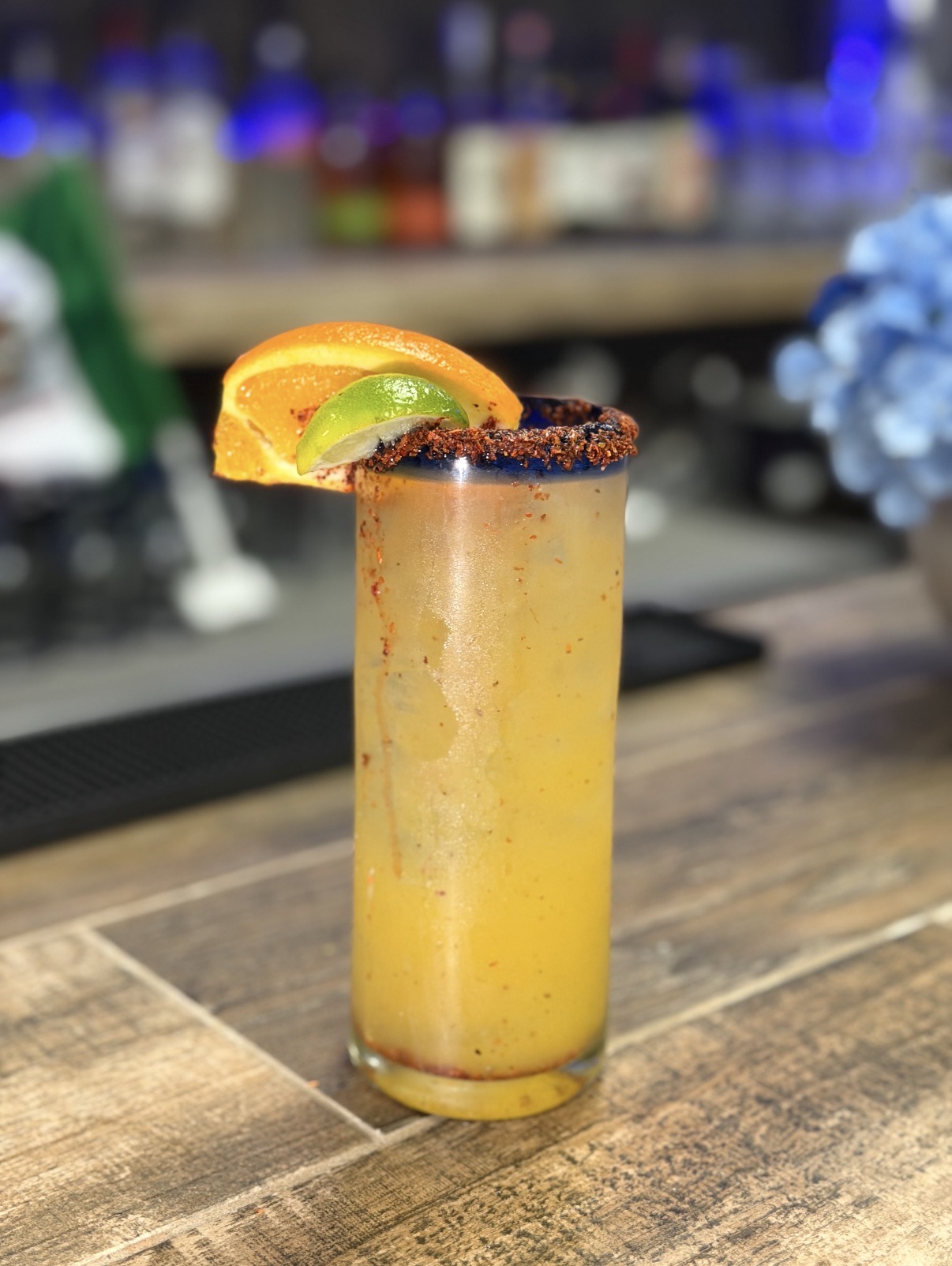 Michelada with a chile-seasoned rim and citrus garnish.