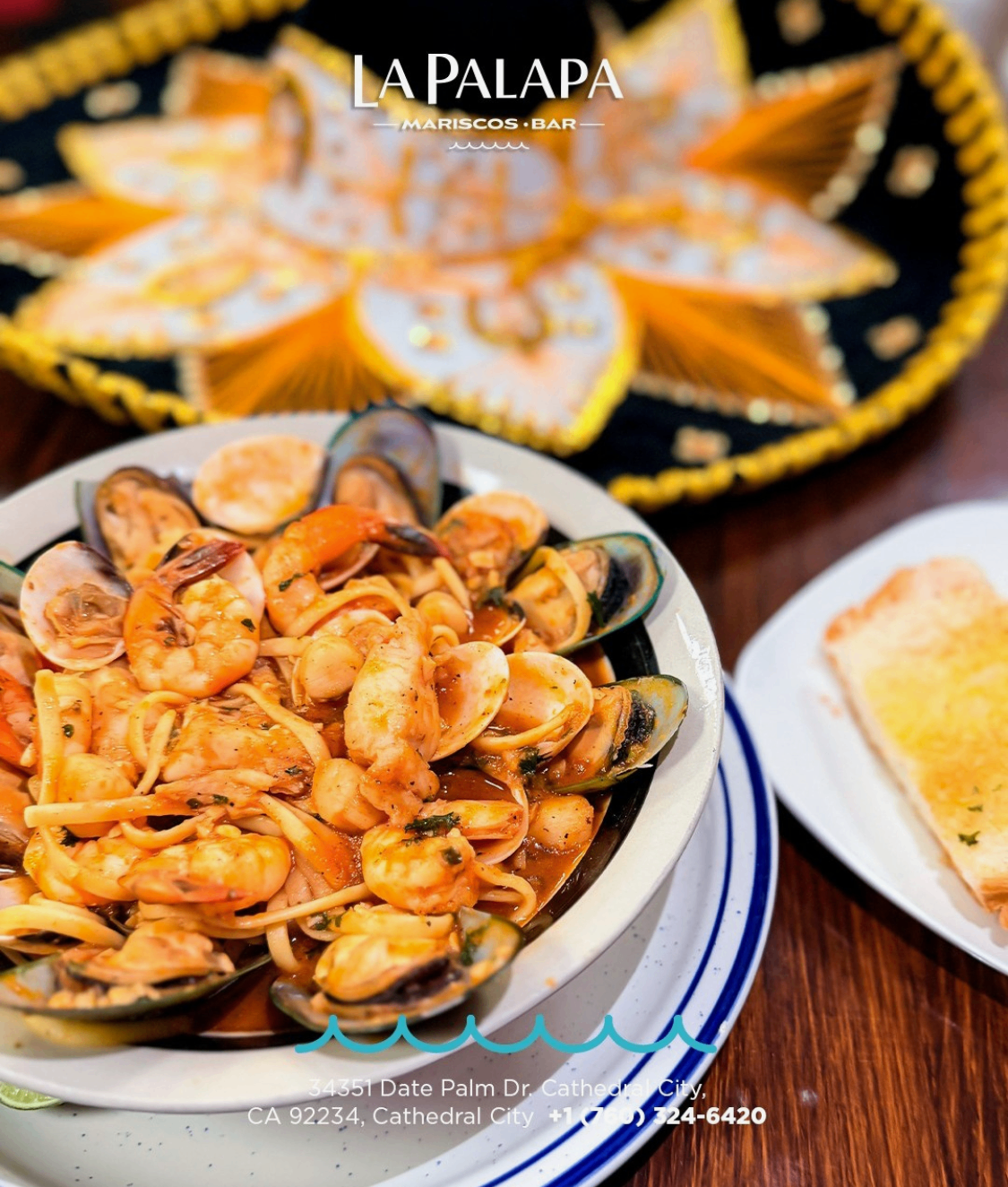 Seafood pasta with shrimp and mussels served with bread.