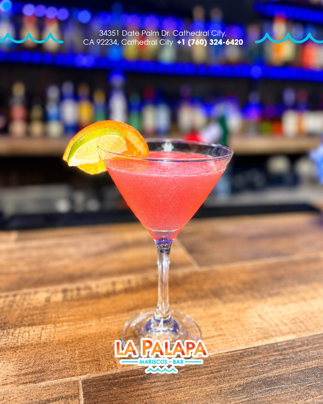 Pink cocktail in a stemmed glass with citrus garnish.